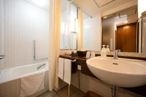 a bathroom with a sink and a bath tub and a sink at Hotel Laforet Shuzenji in Izu