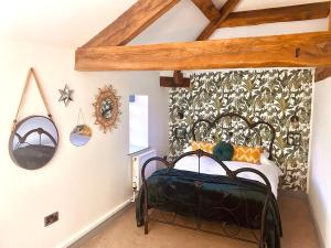 a bedroom with a black bed in a room at North Cottage in Berriew