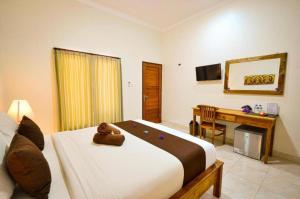 a bedroom with a bed with a teddy bear on it at Canggu Kayuma House in Canggu