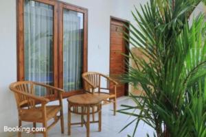 a porch with chairs and a table and a plant at Canggu Kayuma House in Canggu