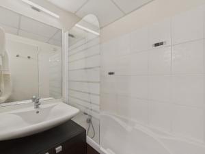 a white bathroom with a sink and a shower at Vue mer avec balcon - Studio pour 2 avec piscine in Le Croisic +4 photos