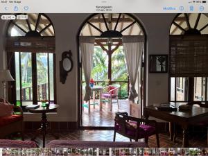 un soggiorno con porte ad arco, tavolo e sedie di Son & Roberto a Karangasem