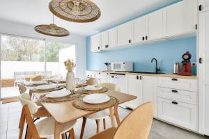 ein Esszimmer mit Tisch und Stühlen in einer Küche in der Unterkunft Jolie maison pour 8 - 400m de la plage - terrasse in La Guérinière