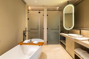 a bathroom with a tub and a shower at Antalya Hotel & Spa, Rishikesh in Rishīkesh +176 photos