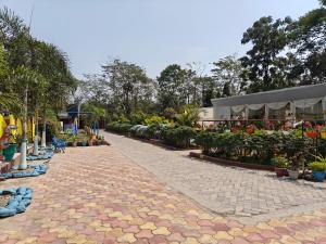 a cobblestone walkway with flowers and plants at Prashaanti Tourist lodge and Restaurant in Bongaigaon