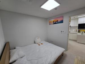 a bedroom with a large white bed with a window at Siaring2room in Seoul
