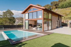 a house with a swimming pool in the yard at Dunas e Abraços in Braga