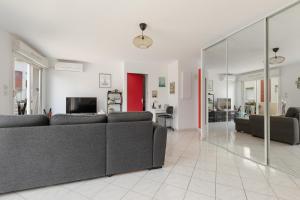 a living room with a couch and a tv at REVE DE MER Duplex 6 pers en bord de plage in Frontignan