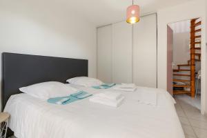 a white bed with towels on top of it at REVE DE MER Duplex 6 pers en bord de plage in Frontignan