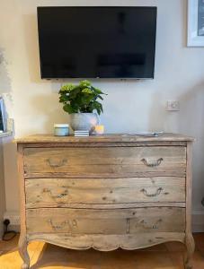eine hölzerne Kommode mit einem TV darüber in der Unterkunft Ringmore Cottage - Salcombe - View over estuary in Salcombe