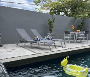 a pool of water with two benches and a toy boat at The Langkawi Luxury - Private Pool Villas & Rooftop Sunset in Pantai Cenang +84 photos