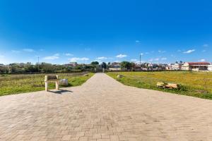 Caprarica di LecceにあるIl Giardino dei Gelsi by BarbarHouseのベンチが2つある公園のレンガの道