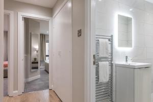 a white bathroom with a sink and a mirror at Stylish, Luxury, Parking Sleeps 6, 2-Bath, City Centre in Belfast