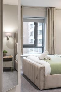 a bedroom with a bed and a window at Stylish, Luxury, Parking Sleeps 6, 2-Bath, City Centre in Belfast