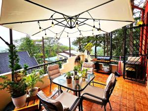 a patio with a table and chairs on a balcony at Transient Guest Room 3A Baguio Wifi Parking in Baguio