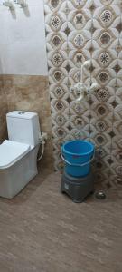 a bathroom with a toilet and a blue bucket at Shree shyam kunj home stay in Vrindāvan