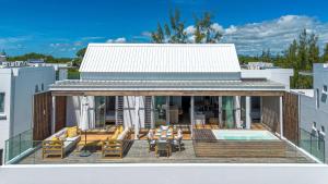 a house with a deck and a swimming pool at Aqua Serena - Luxury Beachfront Penthouse in Grand Gaube