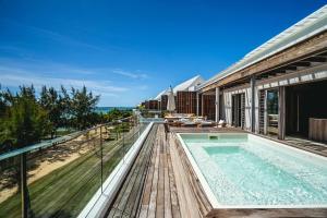a house with a swimming pool and a balcony at Aqua Serena - Luxury Beachfront Penthouse in Grand Gaube