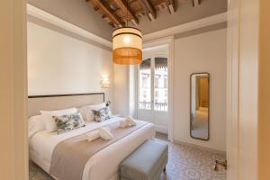 a bedroom with two beds and a mirror at Aladro Apartamentos by Valcambre in Jerez de la Frontera