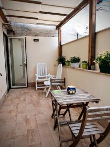 a patio with a wooden table and chairs at Guest House Lo specchio sul mare in Santa Flavia