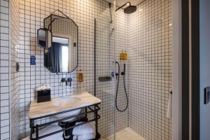 ein Badezimmer mit Waschbecken und Dusche in der Unterkunft COQ Hotel Paris in Paris