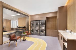 a laundry room with three washer and dryer at Home2 Suite by Hilton Hengshui Taocheng in Hengshui