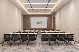 a conference room with tables and chairs and a white screen at Home2 Suite by Hilton Hengshui Taocheng in Hengshui