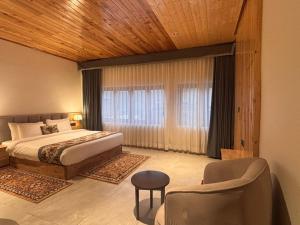 a bedroom with a bed and a large window at Avongrove Tea Boutique Bungalows By Mount Hotels in Mirik