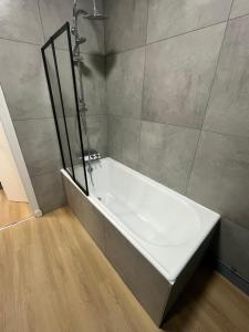 a white bath tub in a bathroom with a shower at Les balcons du 115 BIS - Appartement standing in La Bourboule