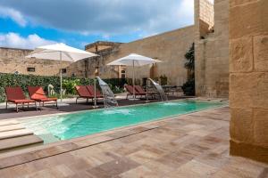 Palazzo Corte Dei Granai Raro Villas Homes Collection في ماليي: مسبح وكراسي ومظلات بجانب مبنى