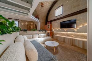 Palazzo Corte Dei Granai Raro Villas Homes Collection في ماليي: غرفة معيشة مع أريكة وتلفزيون