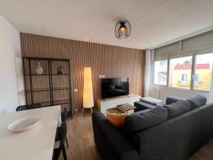 ein Wohnzimmer mit Sofa und Fernseher in der Unterkunft YourHouse Balcon de las Mareas in Corme-Puerto