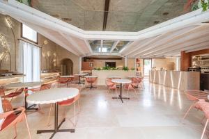 Palazzo Corte Dei Granai Raro Villas Homes Collection في ماليي: مطعم به طاولات وكراسي في غرفة