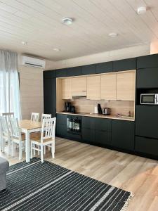 a kitchen with a table and chairs in a room at Kotimaailma Apartments Patokuja in Kempele