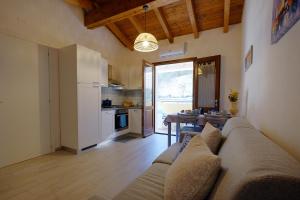 a living room with a couch and a kitchen at Dimora blù al centro in Teulada