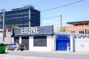 una mujer parada frente a un edificio con un garaje azul en Tsiriry Guest House, en Antananarivo