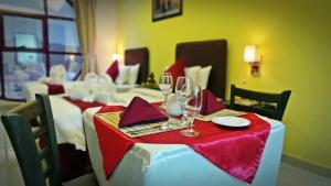una mesa con copas de vino y servilletas. en Mirage Hotel Al Aqah en Al Aqah