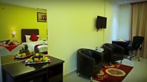 Habitación de hotel con cama y mesa con fruta. en Mirage Hotel Al Aqah, en Al Aqah
