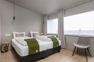 海拉Stracta Hotel Mosfell的一间卧室，里面有一张床、一把椅子和一扇窗户