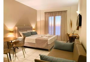 a hotel room with a bed and a table at Sunset Premium Studio 12 in Agios Nikitas