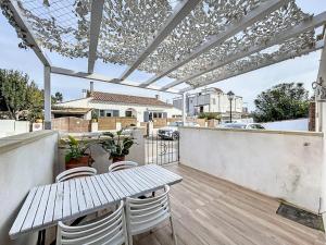 Un patio con una mesa y sillas en un balcón. en Appartement le loft, en Saintes-Maries-de-la-Mer