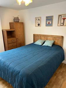 a bedroom with a blue bed and a dresser at L'Ancrage in Saint Malo