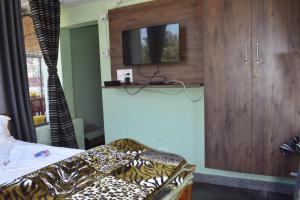 a room with a bed and a tv on a wall at Yelagiri GoldHill Resort in Yelagiri