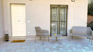 two chairs and a table in front of a door at Serenity Suites Rimini - Affitti Brevi Italia in Rimini