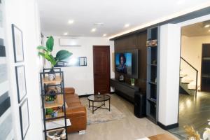 een woonkamer met een bank en een televisie bij Casa Junquera in Cebu City
