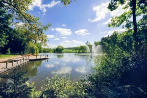 a view of a pond with a fountain in the distance at Schwarzwald Style DreiWelten Card inkl freier Eintritt Solemar Ruhige Fewo mit 85 qm zentral Parkanlage Stellplatz in Bad Dürrheim