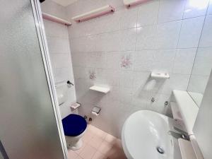 a white bathroom with a toilet and a sink at Casa Soprana in Capoliveri