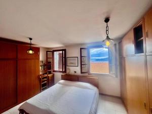 a bedroom with a white bed and a window at Casa Soprana in Capoliveri
