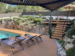 Un patio con mesa y sillas junto a una piscina. en Villa Vicente, en Canyelles