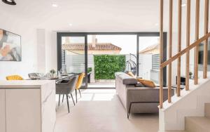 a kitchen and living room with a couch and a table at Seaview house with rooftop pool, game room, parking REMS in Torremolinos